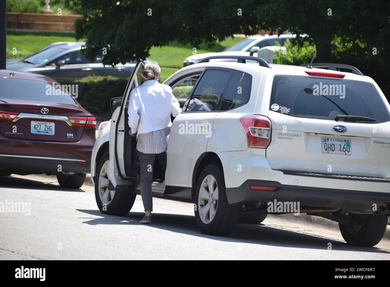 Ältere Frau, die ihren weißen Subaru Forester betritt – Mai 2023 Stockfoto