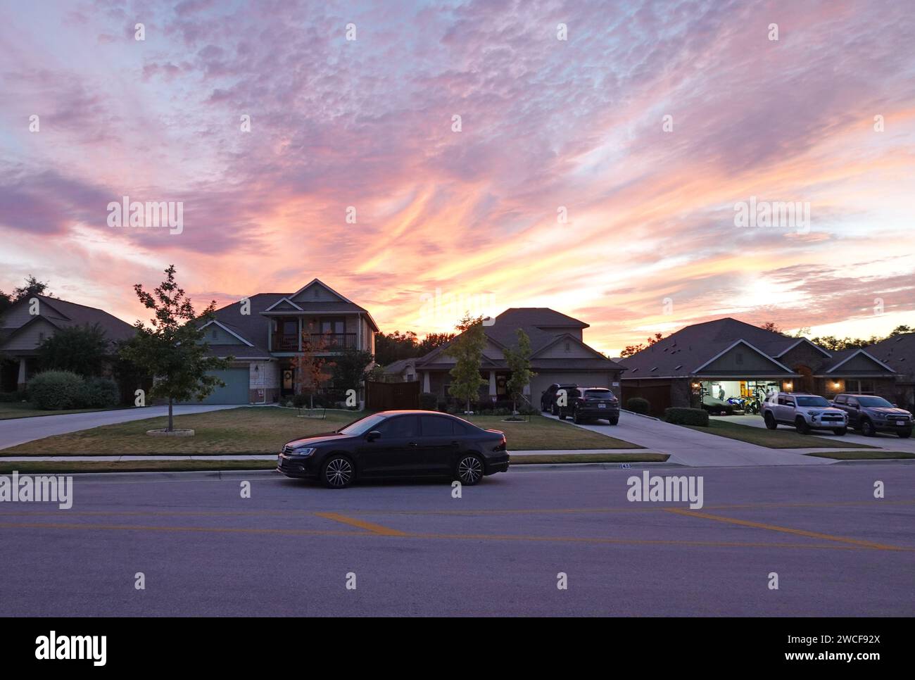 Ein Volkswagen Jetta parkte vor einem Vorstadthaus in Texas in der Abenddämmerung - November 2023 Stockfoto
