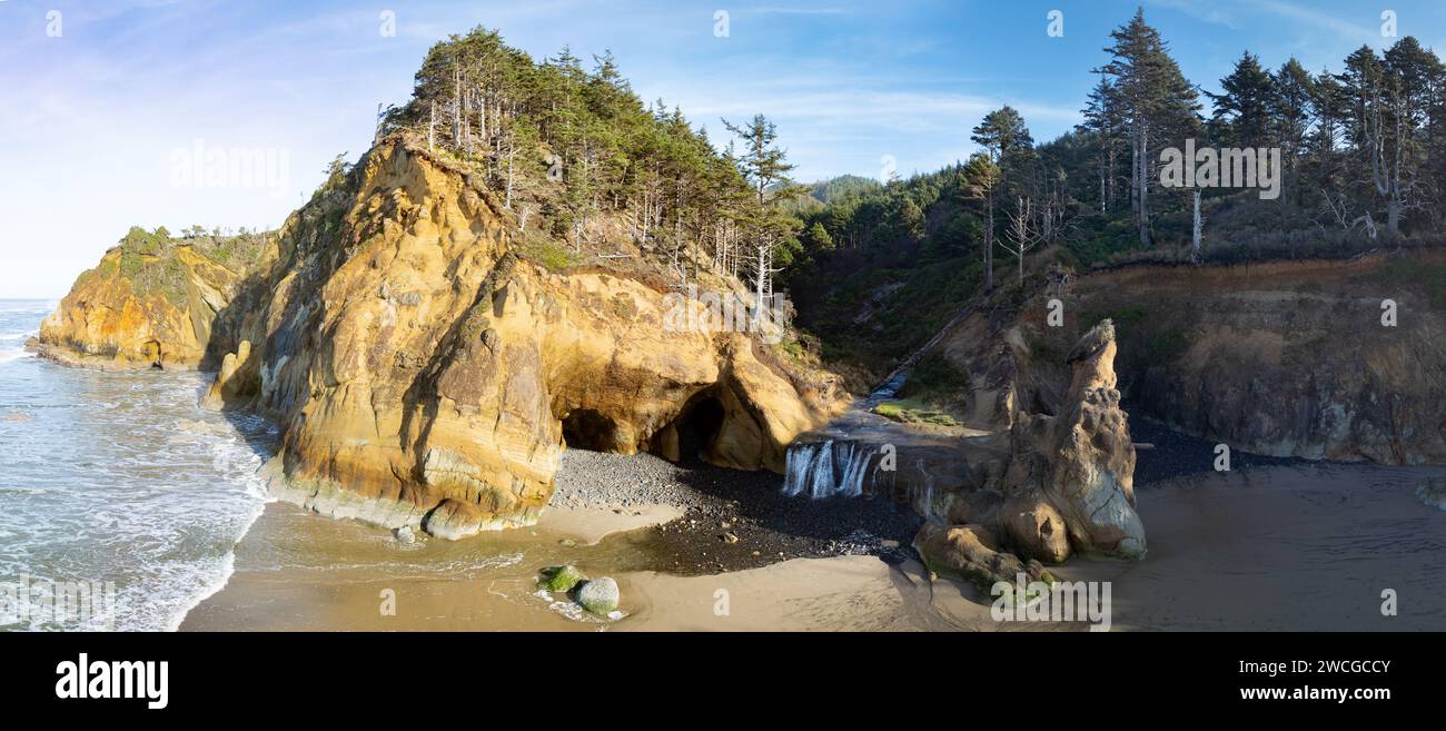 Sonnenlicht scheint an der Küste Oregons in der Nähe des Hug Point, wo sich ein Wasserfall befindet. Diese Region ist bekannt für ihre malerischen Strände und Meeresstrände. Stockfoto