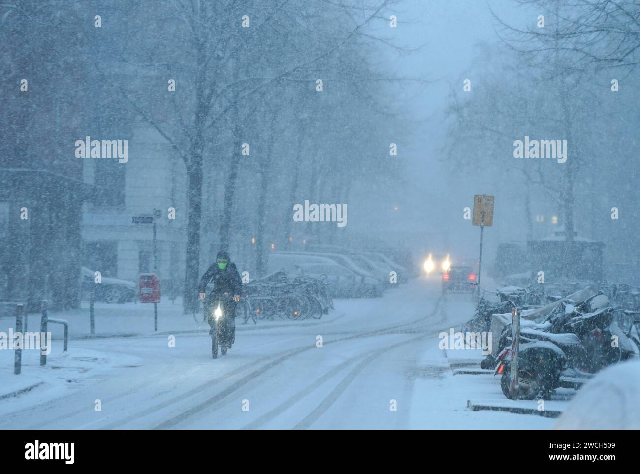 Hamburg, Deutschland. Januar 2024. Ein Radfahrer fährt auf einer schneebedeckten Straße. Der Winter ist wieder in Deutschland. Neuschnee und vereiste Straßen haben zu mehreren Unfällen geführt. Die Unbedenklichkeit für vereiste Straßen ist vorerst nicht in Sicht. Quelle: Marcus Brandt/dpa/Alamy Live News Stockfoto