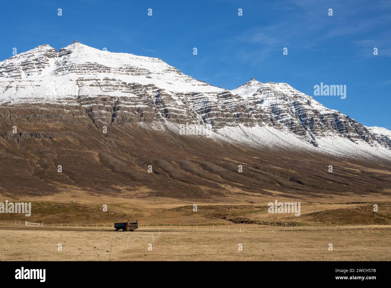 Schnee auf dem Gipfel des Berges im Herbst, wenn das restliche Land leer ist. Hellblauer Himmel. Lage in der Nähe von Neskaupstadur, Ost-Island. Stockfoto