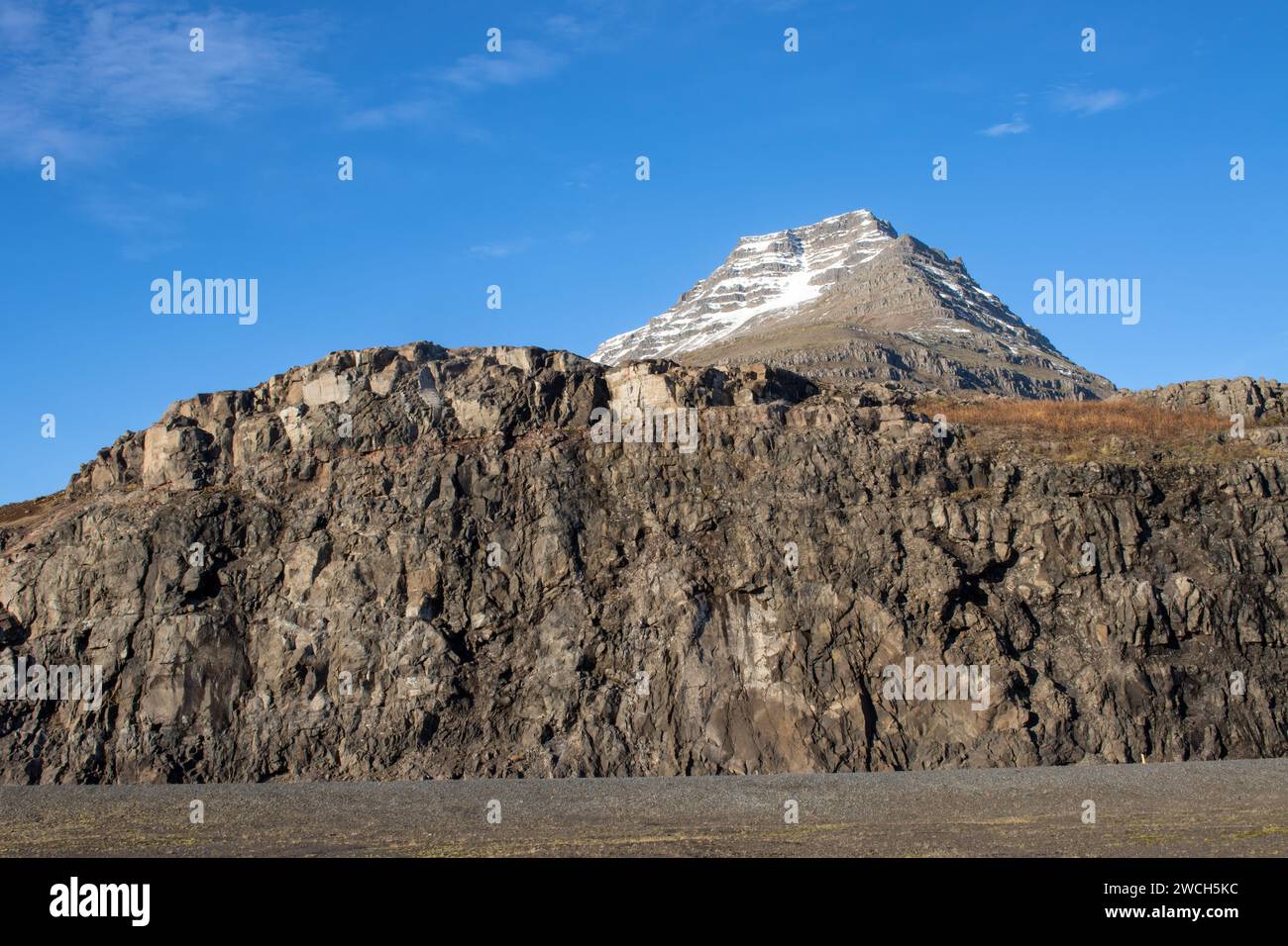 Schnee auf dem Gipfel des Berges im Herbst, wenn das restliche Land leer ist. Hellblauer Himmel. Lage in der Nähe von Neskaupstadur, Ost-Island. Stockfoto