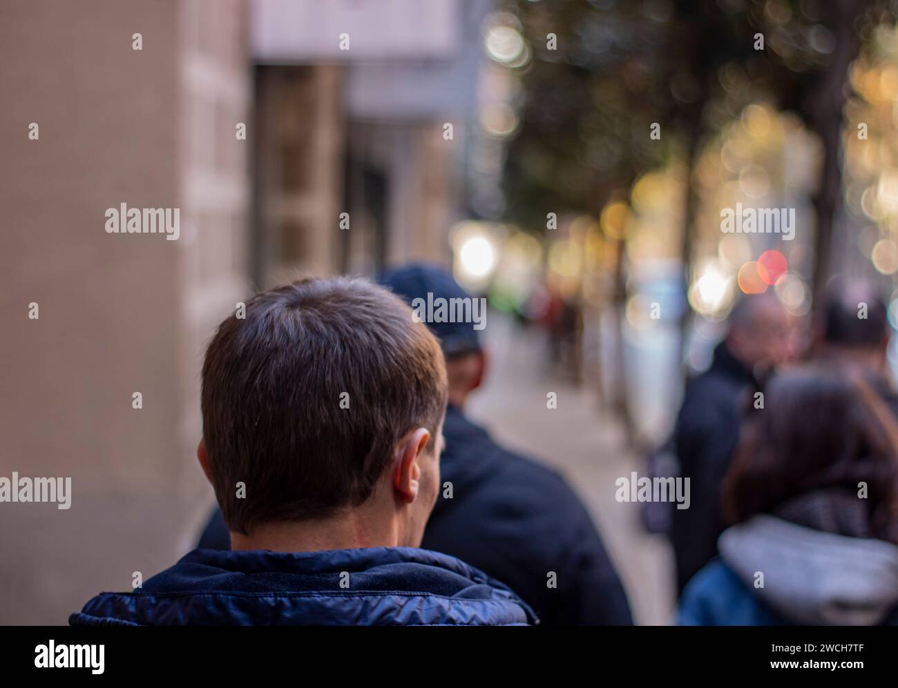 Ein Mann, der die Straße von Barcelona entlang läuft. Rückansicht eines Mannes. Der Hintergrund ist unscharf. Stockfoto