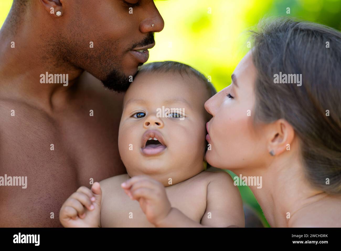 Outdoor-Porträt für gemischte Rassen. Gemischte Rasseneltern mit Kleinkind auf der Natur. Porträt eines glücklichen afroamerikanischen oder hispanischen Vaters und Stockfoto