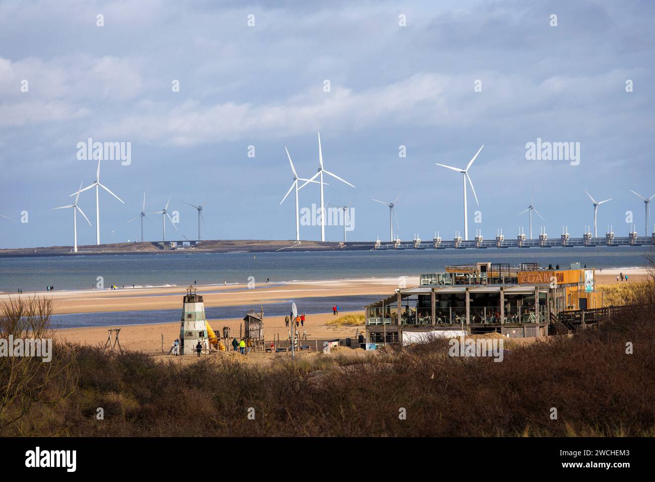 Der Strandpavillon de Dam am am Strand bei Vrouwenpolder auf Walcheren, im Hintergrund Windräder an der östlichen Scheldsperre, Zeeland, Niederlande Stockfoto