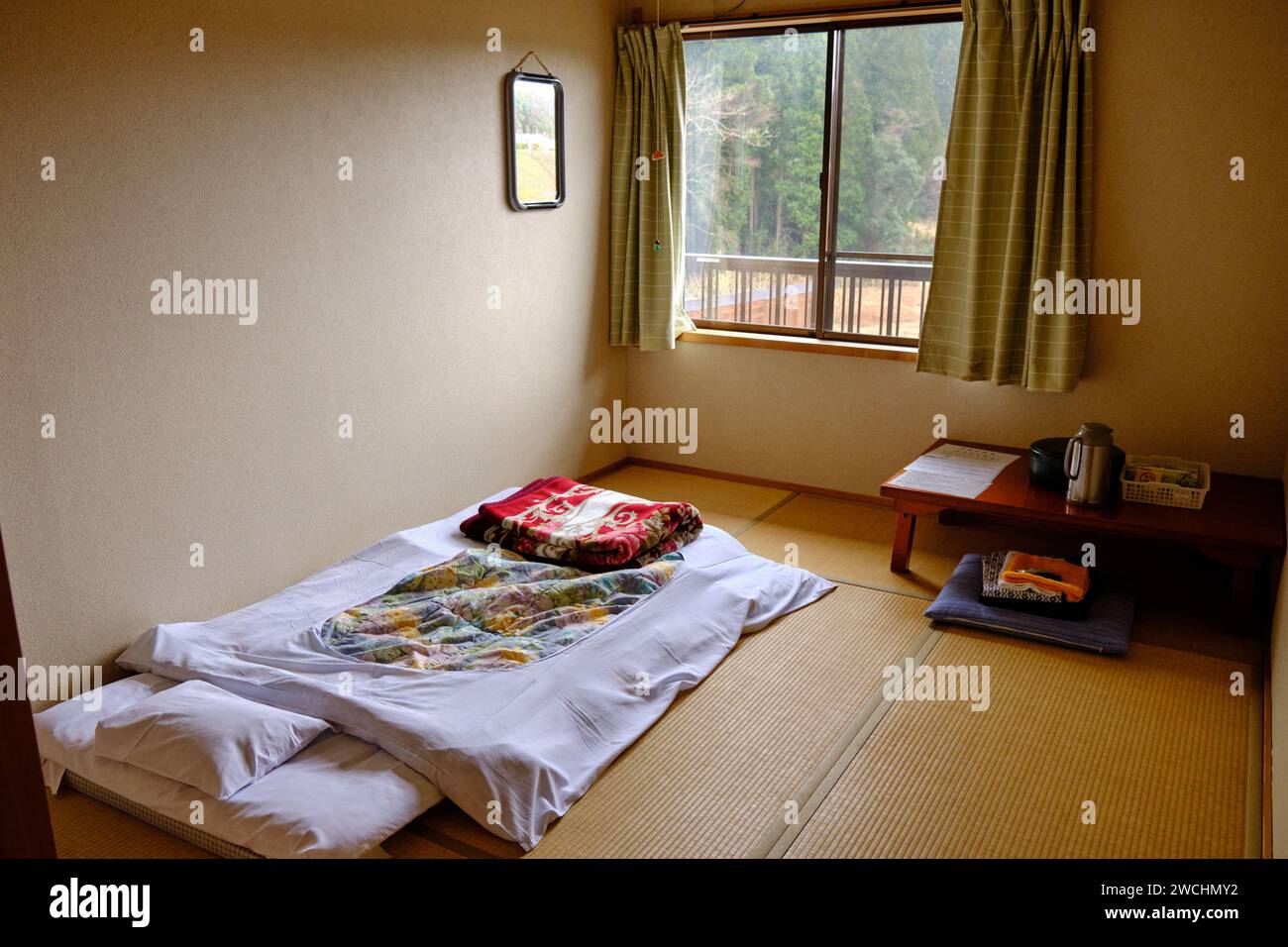 Schlafzimmer in einem typischen Minshuku, ein familienbetriebenes, japanisches Bett und Frühstück, mit Bettwäsche und kleinem Tisch mit Teezubereiter Stockfoto