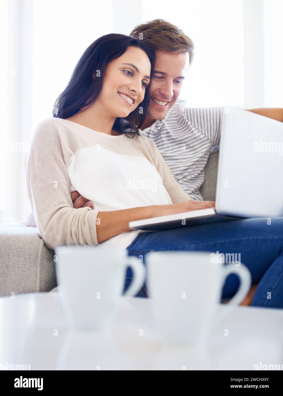 Paare, Laptop und Filme auf Sofa mit Liebe, Wohnzimmer und Wellness in der Ehe für Bindungen. Frau, Mann und Lächeln für die Beziehung Stockfoto