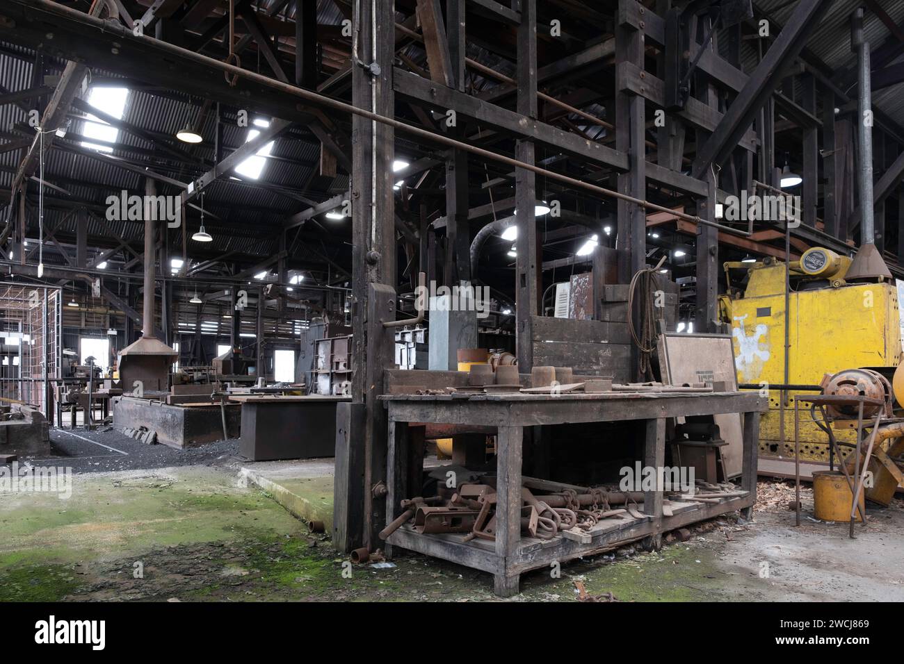 Innenraum des Schmiedewerkes, in dem Männer arbeiteten, um erhitztes Metall von Hand und Maschine zu Formen, im Queen Victoria Museum in Inveresk Stockfoto