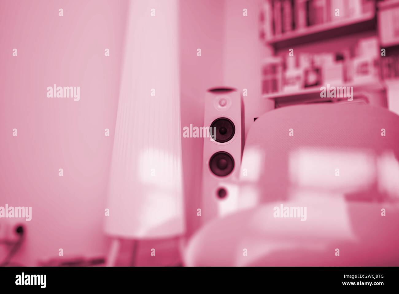 Ein luxuriöses Wohnzimmer in sanften Rosa-Tönen mit großen Lautsprechern und einem eleganten Lampenschirm. Ein Ambiente mit Raffinesse und Stil Stockfoto