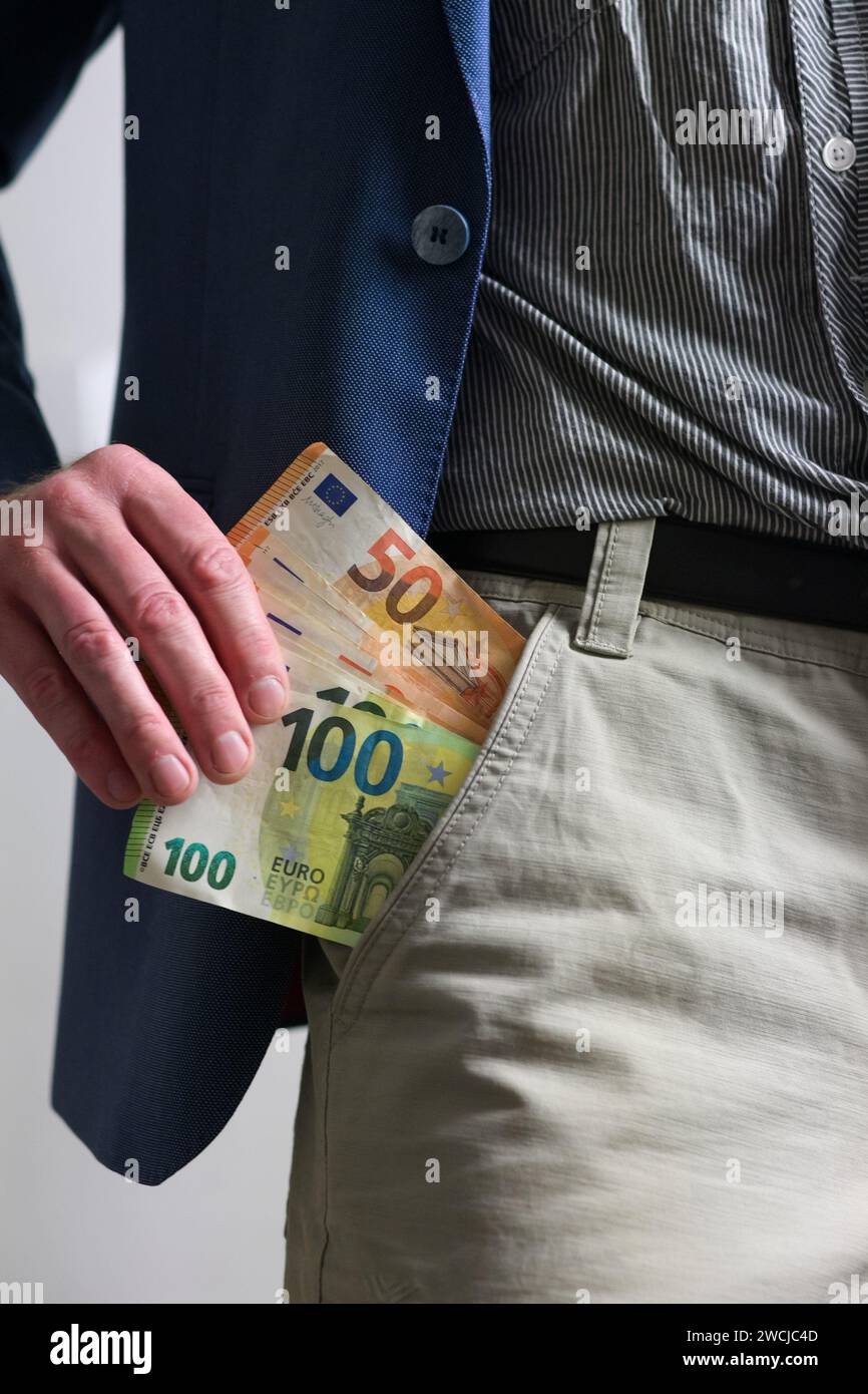 Ein Typ in einem blauen Anzug und einer leichten Hose zieht Geld aus seiner Tasche, aus der Nähe. Stockfoto