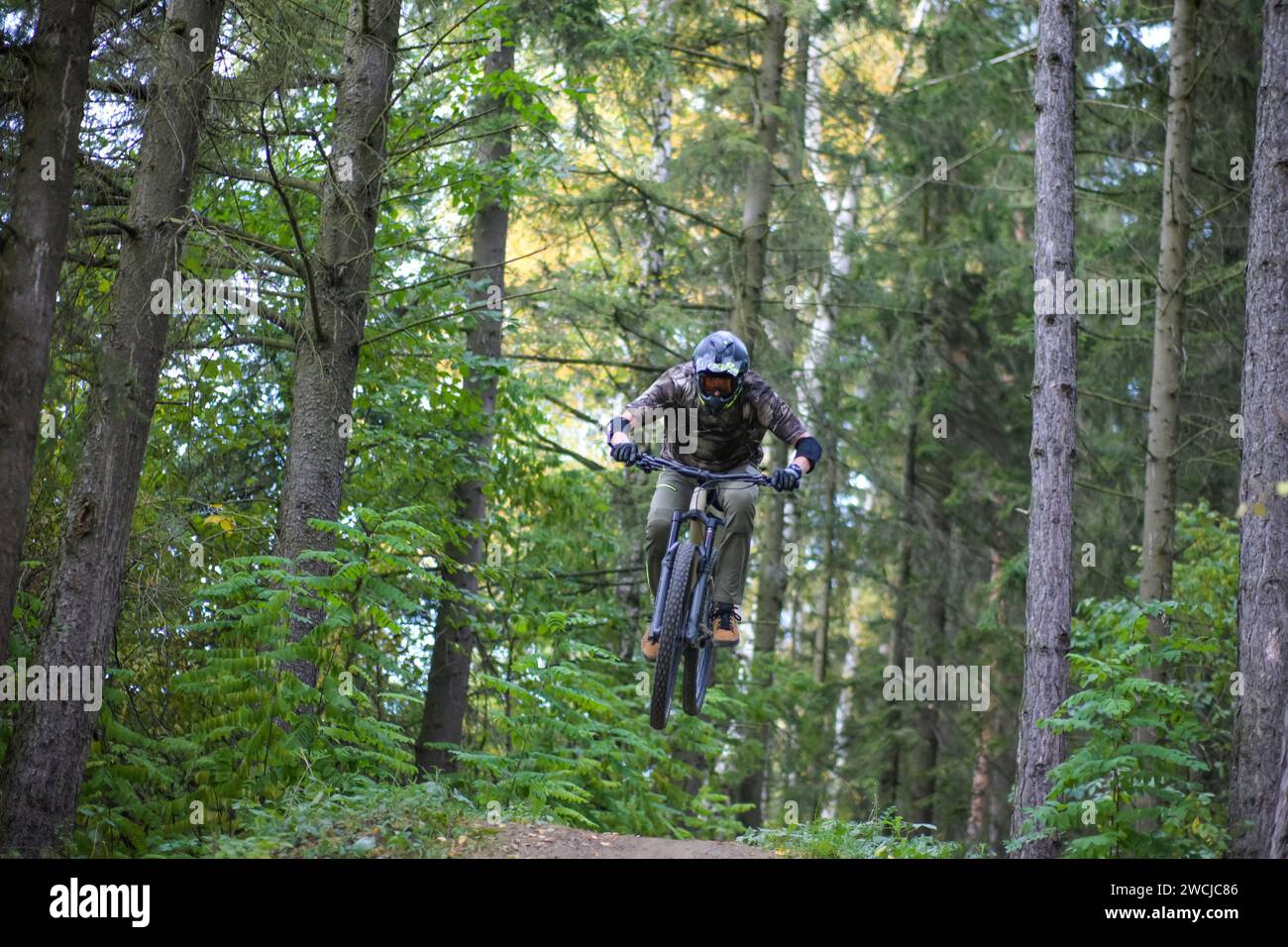 Profi-Athlet Hochsprung auf einem Mountainbike im Wald, aus nächster Nähe. Stockfoto