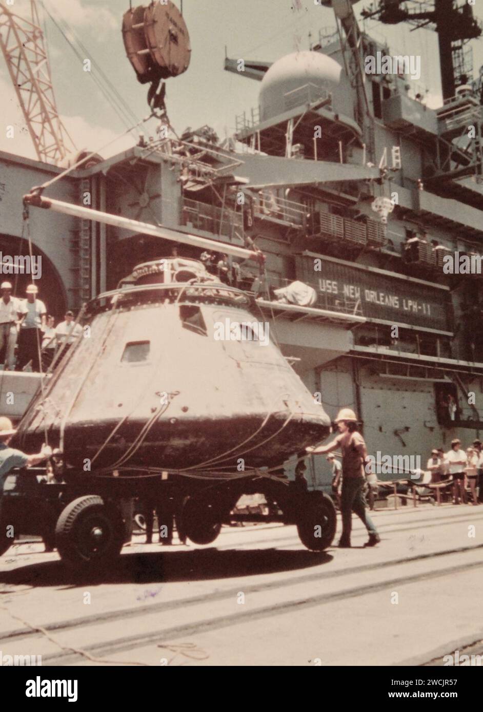Ein Kran senkt die Apollo CSM-111 Kapsel am 25. Juli 1975 (428-GX-K-109709) auf den Pier in Pearl Harbor ab, nachdem sie von der USS New Orleans (LPH-11) entladen wurde. Stockfoto