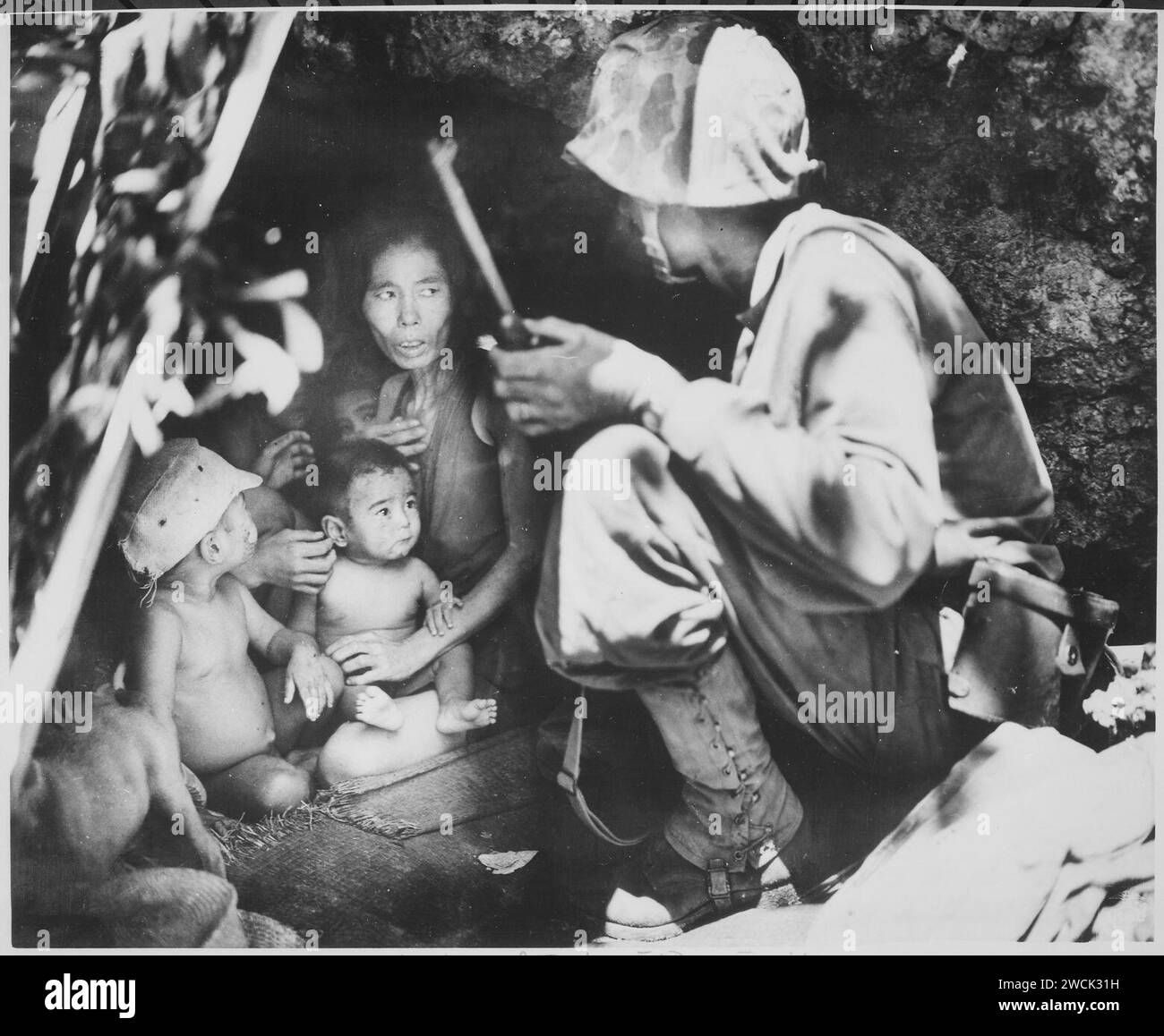 Ein Mitglied einer Marinepatrouille auf Saipan fand diese Familie Japans in einer Höhle am Hügel. Die Mutter, vier Kinder und Stockfoto