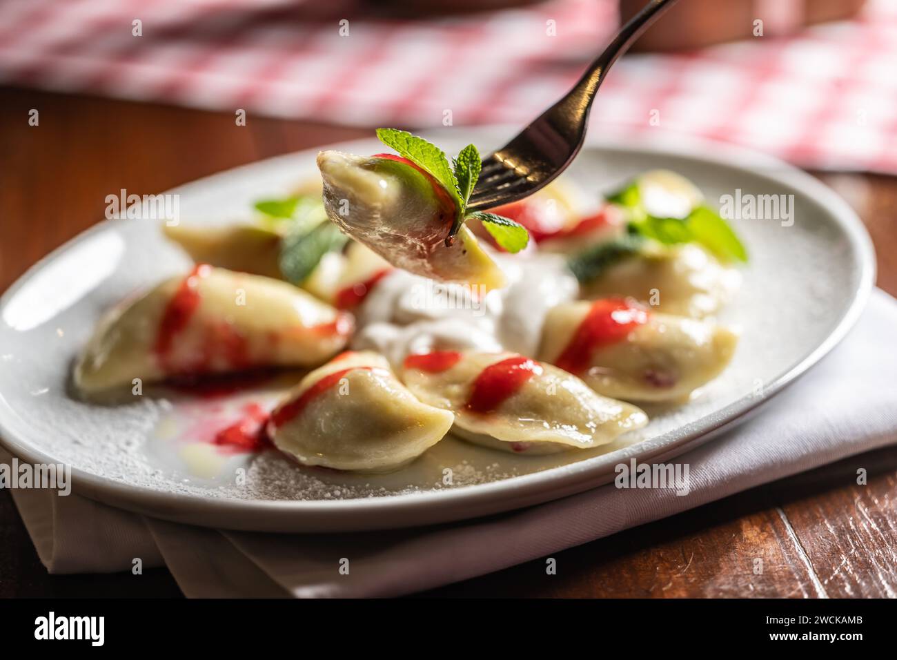 Traditionelle osteuropäische Essensklöße - Pierogi, Varenyky, pirohes gefüllt mit Erdbeeren und garniert mit Marmelade. Stockfoto