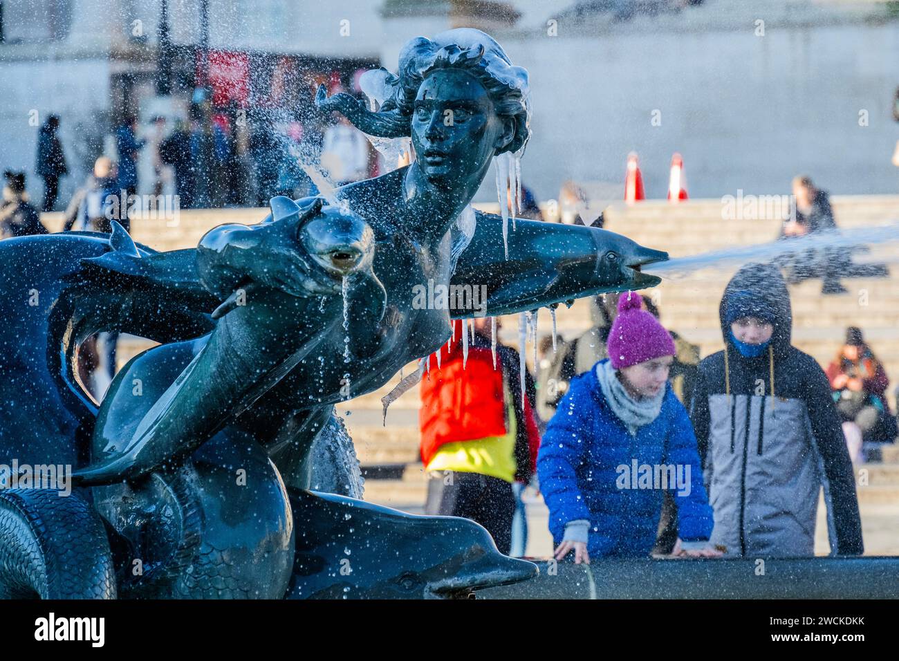 London, Großbritannien. Januar 2024. Passanten sind gut eingepackt, da das Wasser in den Springbrunnen am Trafalgar Square sehr kalt ist. Guy Bell/Alamy Live News Stockfoto