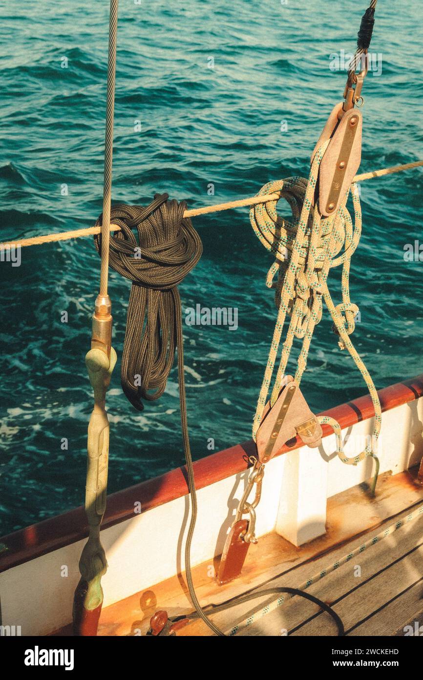Ein robustes Seil, das am Bug eines Bootes verankert ist, das auf ruhigem Wasser schwimmt Stockfoto