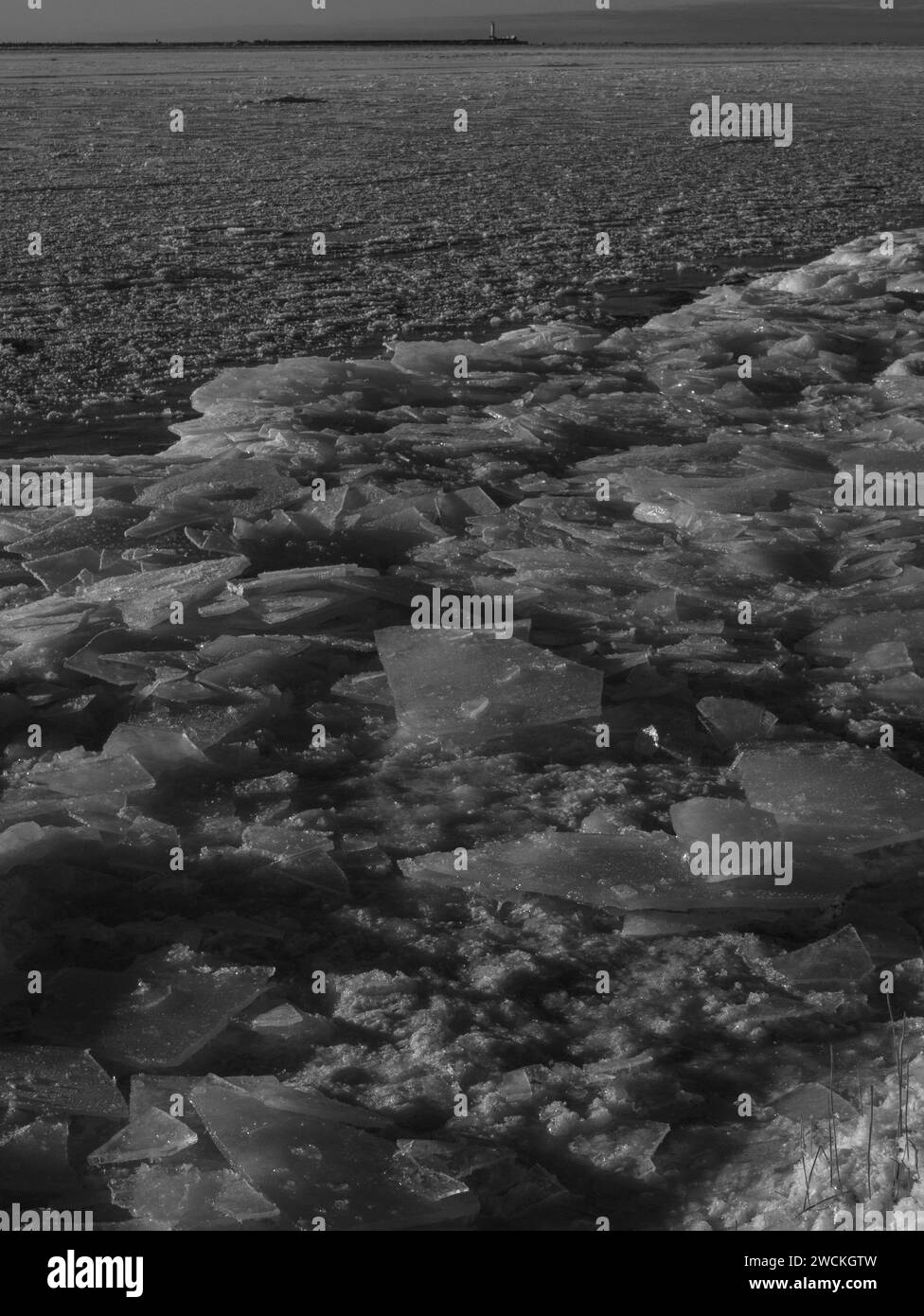 Schwarz-weiße Winterlandschaft mit gefrorenem Eismeer und Leuchtturm auf einem Hintergrund Mangalsala riga 09.01.2024 Stockfoto