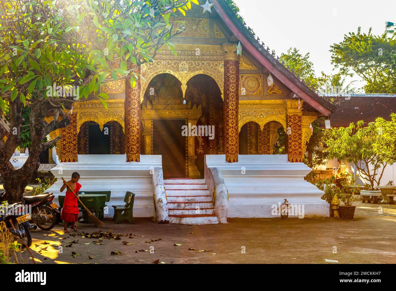 Ein junger Mönch (Samanera), der vor dem buddhistischen Tempel des Wat Sibounheuang in Luang Prabang, laos, reist Stockfoto