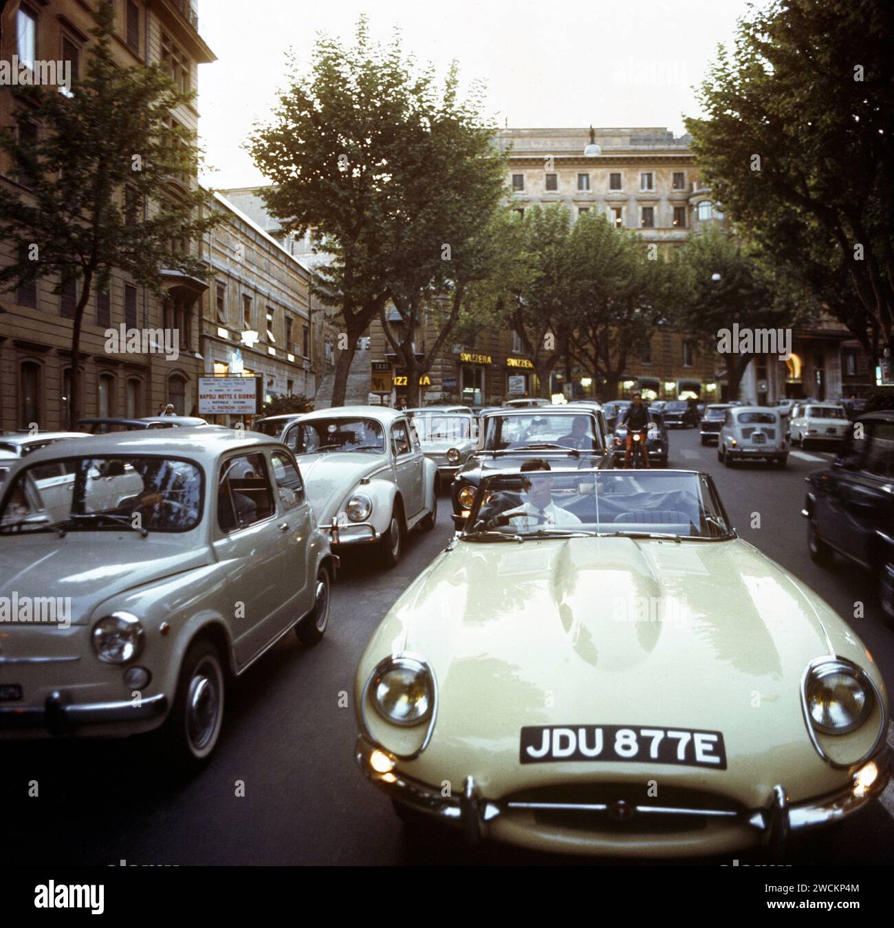 1967 Jaguar E-TYPE, JDU877E, im „West End“ von Rom, während der Hauptverkehrszeit, umgeben von Verkehr und Theaterbesuchern, um Napoli Notte e Giorno zu sehen. Stockfoto