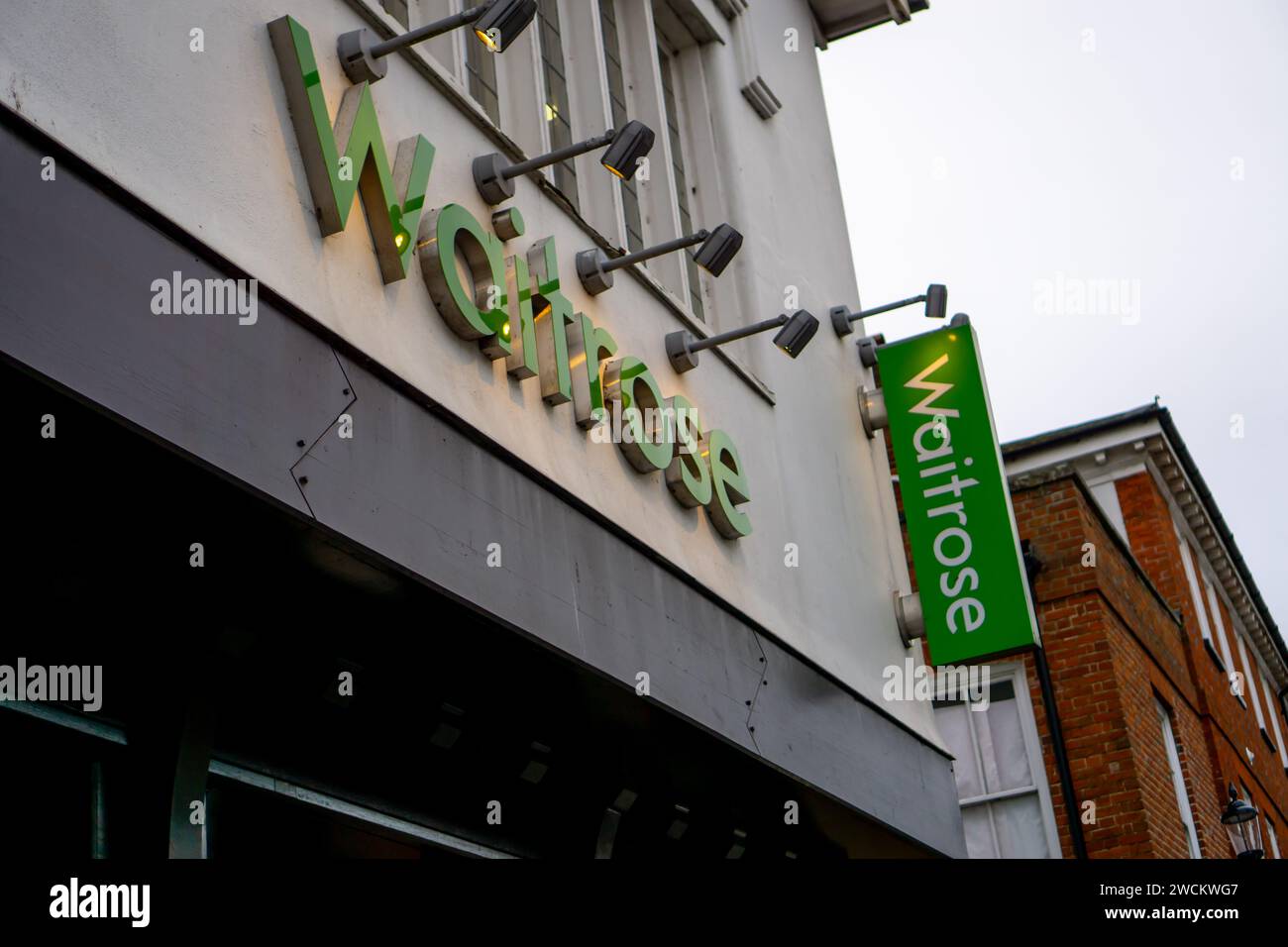 Beleuchtetes Ladenschild für den Waitrose-Supermarkt mit zusätzlichem vertikalem Schild Stockfoto