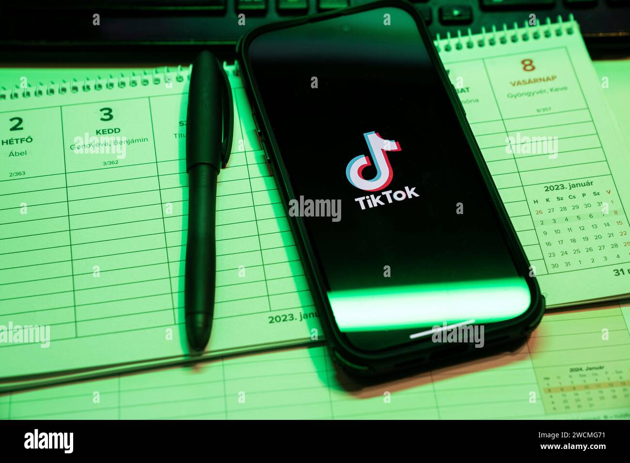 Tik Tok Anwendung auf dem Bildschirm des Apple iPhone 14 Pro Max Smartphones auf der linken Hintergrundtabelle. Büroumgebung. Budapest, Ungarn. Nove Stockfoto
