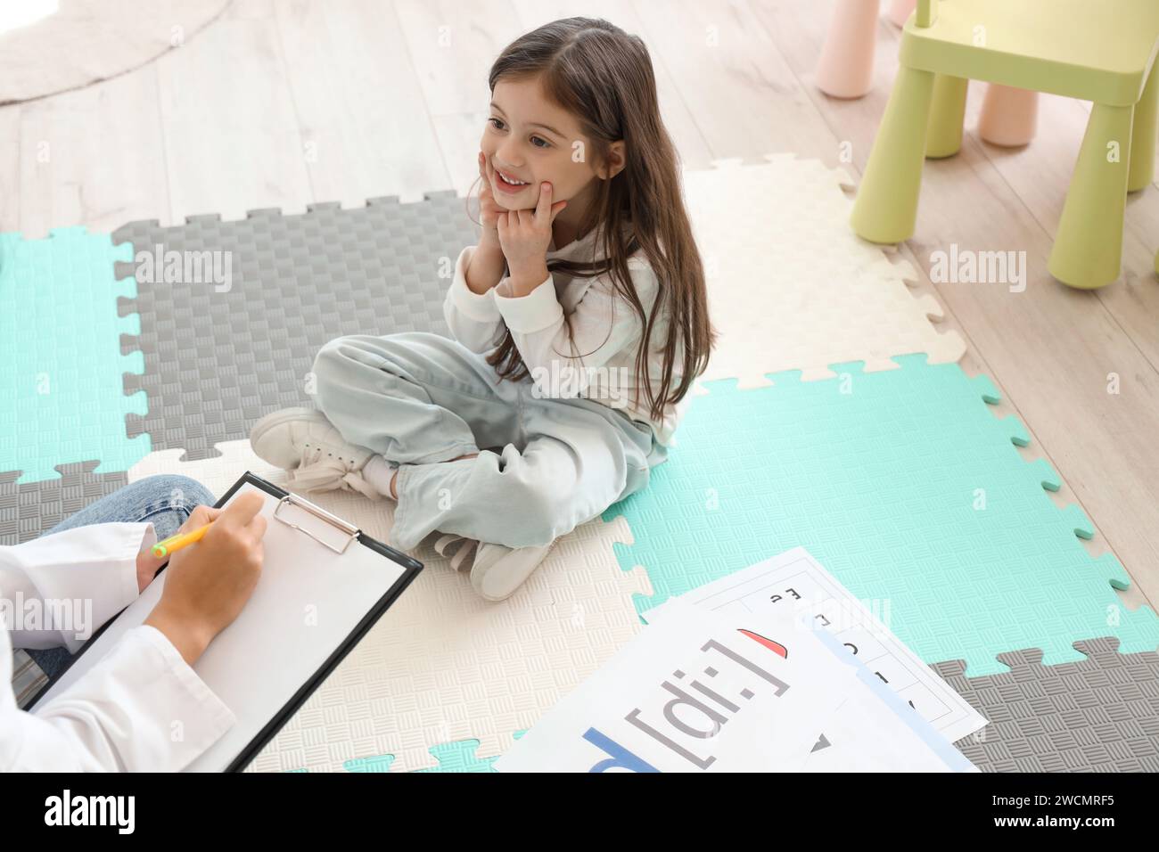 Kleines Mädchen, das einen Brief in der Praxis des Logopäden ausspricht Stockfoto