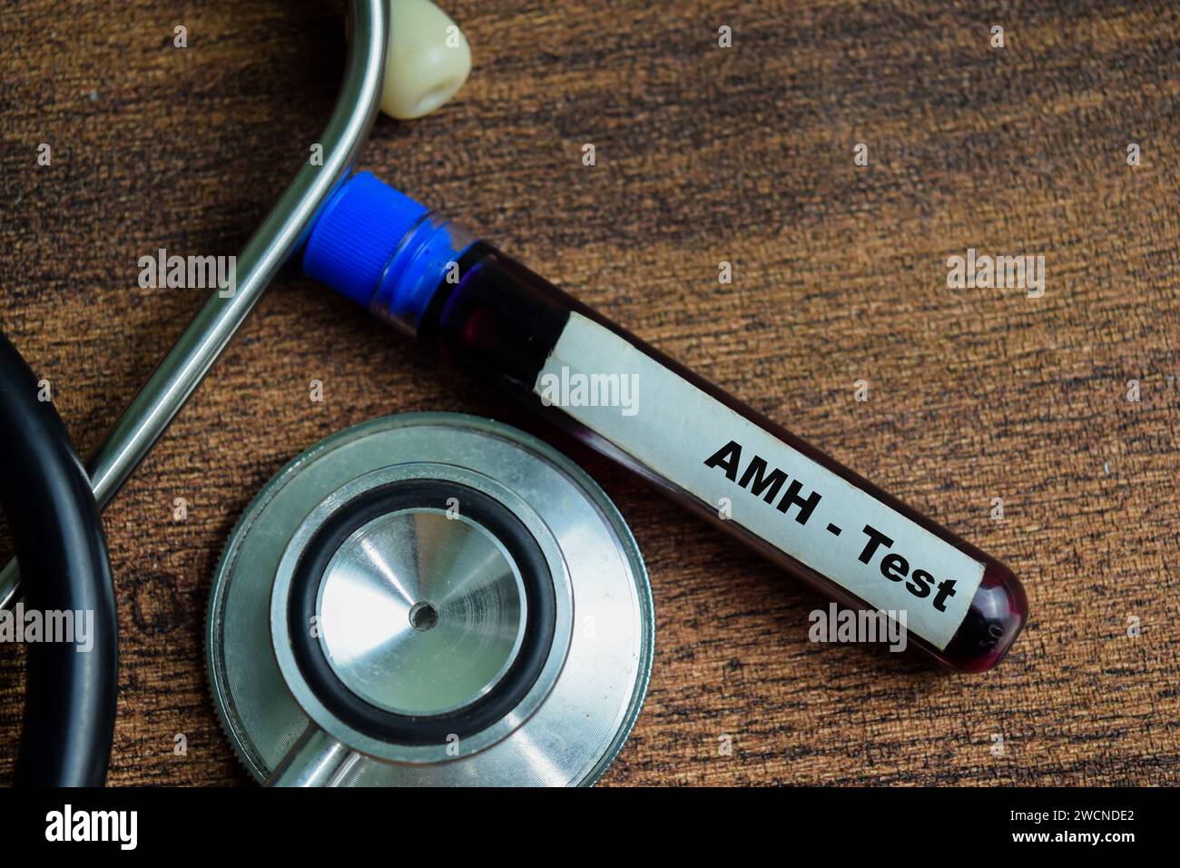 AMH - Test mit Blutprobe auf hölzernem Hintergrund. Gesundheitswesen oder medizinisches Konzept Stockfoto