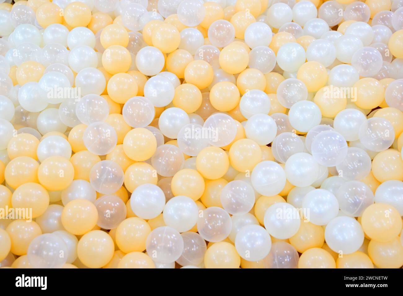 Eine Nahaufnahme weißer und gelber Ballons, die in einem Stapel oder Behälter gesammelt wurden Stockfoto