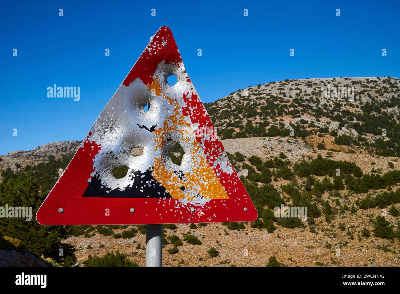 Zertrümmertes Straßenschild vor einem Hügel und blauem Himmel, in der Nähe von Askifou, Sfakia, Westkreta, Kreta, Griechenland Stockfoto