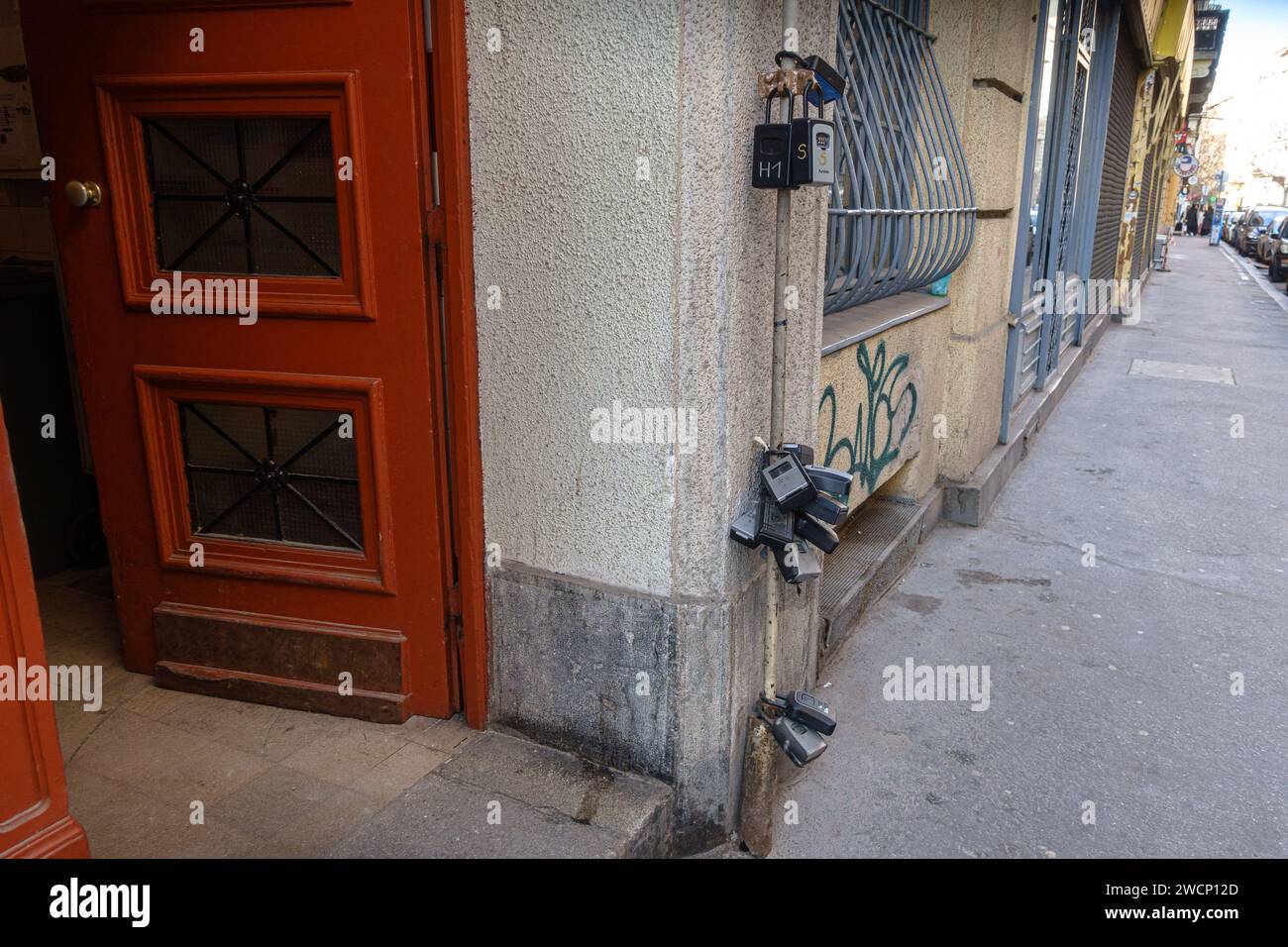 Viele Schlüsselsafes an einem Pol neben einem Gebäudeeingang, was auf Übertourismus hinweist Stockfoto