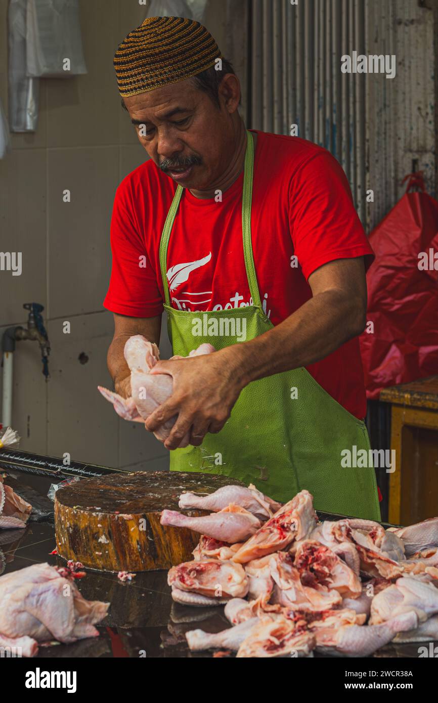 Der Verkäufer überprüft und reinigt das Hühnerfleisch. Stockfoto