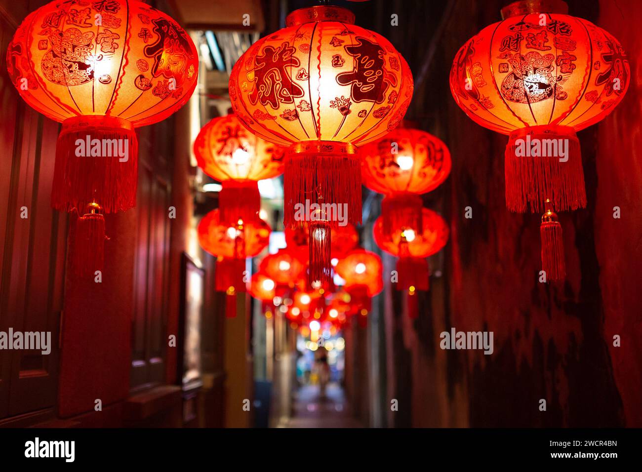 Traditionelle chinesische rote Laternen hängen in der kleinen Gasse. Stockfoto