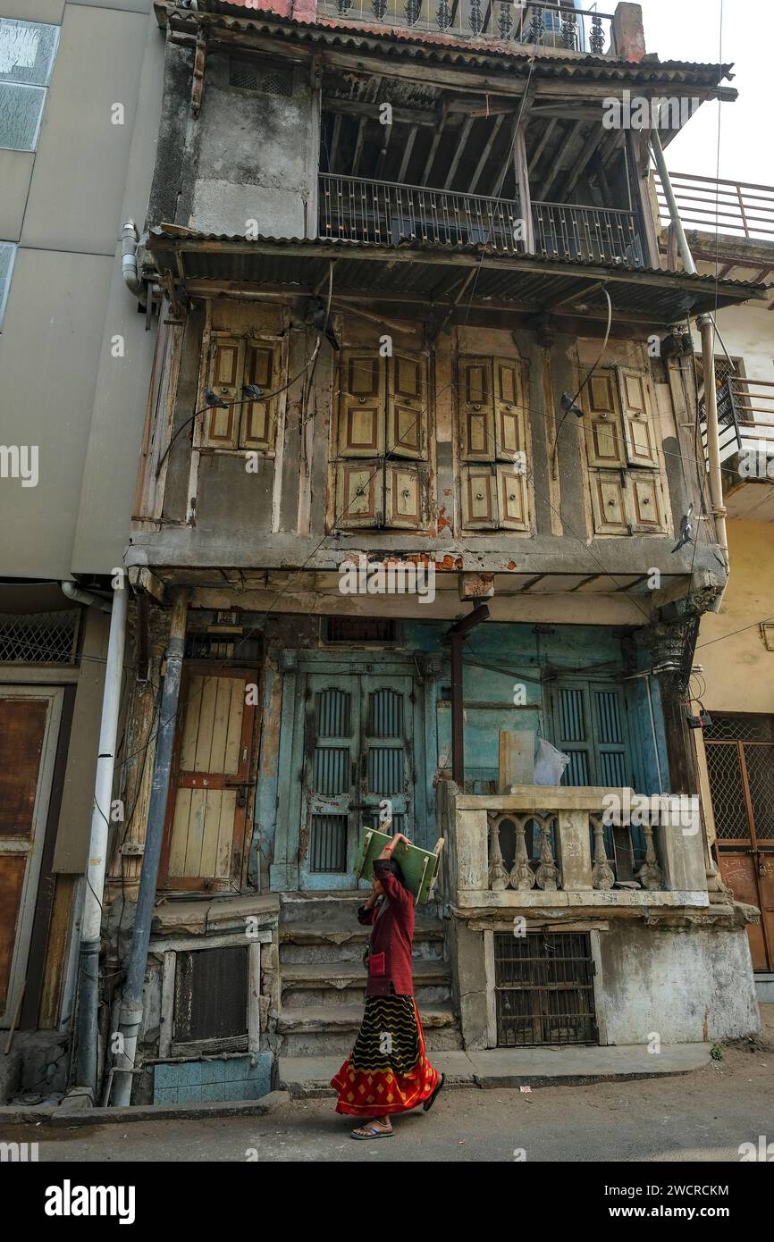 Ahmedabad, Indien - 10. Januar 2024: Eine Frau, die einen kleinen Tisch durch die Altstadt von Ahmedabad trägt. Stockfoto