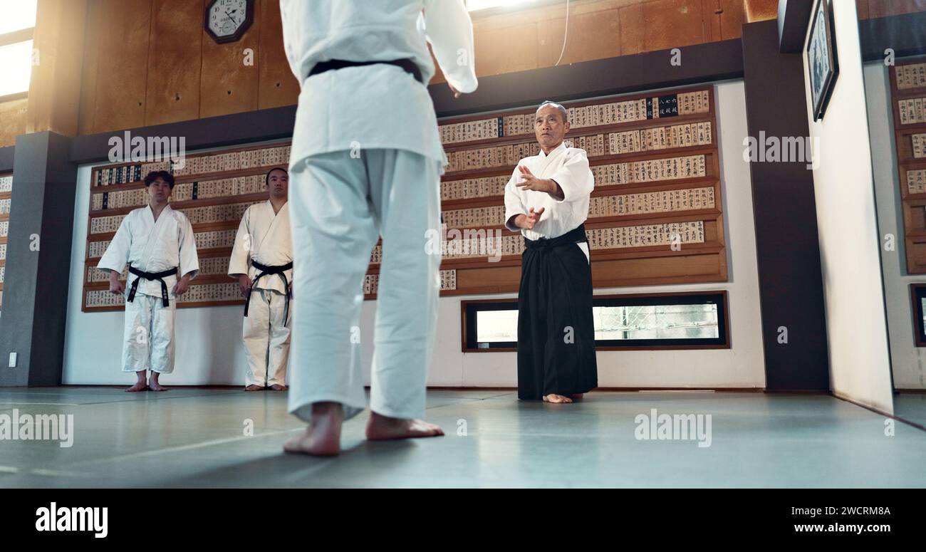 Aikido-, Sensei- und japanische Studenten mit Fitness, Training und Aktion in der Klasse für Verteidigung oder Technik. Kampfkünste, Menschen oder Kämpfe mit Stockfoto