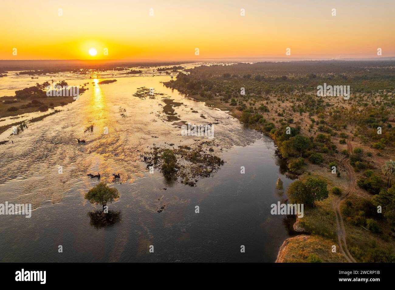 Der Sonnenaufgang kann über dem Sambesi-Fluss im Simbabwes Zambezi-Nationalpark, Victoria Falls, beobachtet werden. Stockfoto