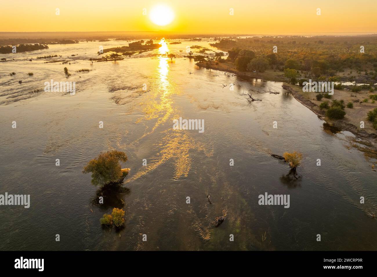 Der Sonnenaufgang kann über dem Sambesi-Fluss im Simbabwes Zambezi-Nationalpark, Victoria Falls, beobachtet werden. Stockfoto