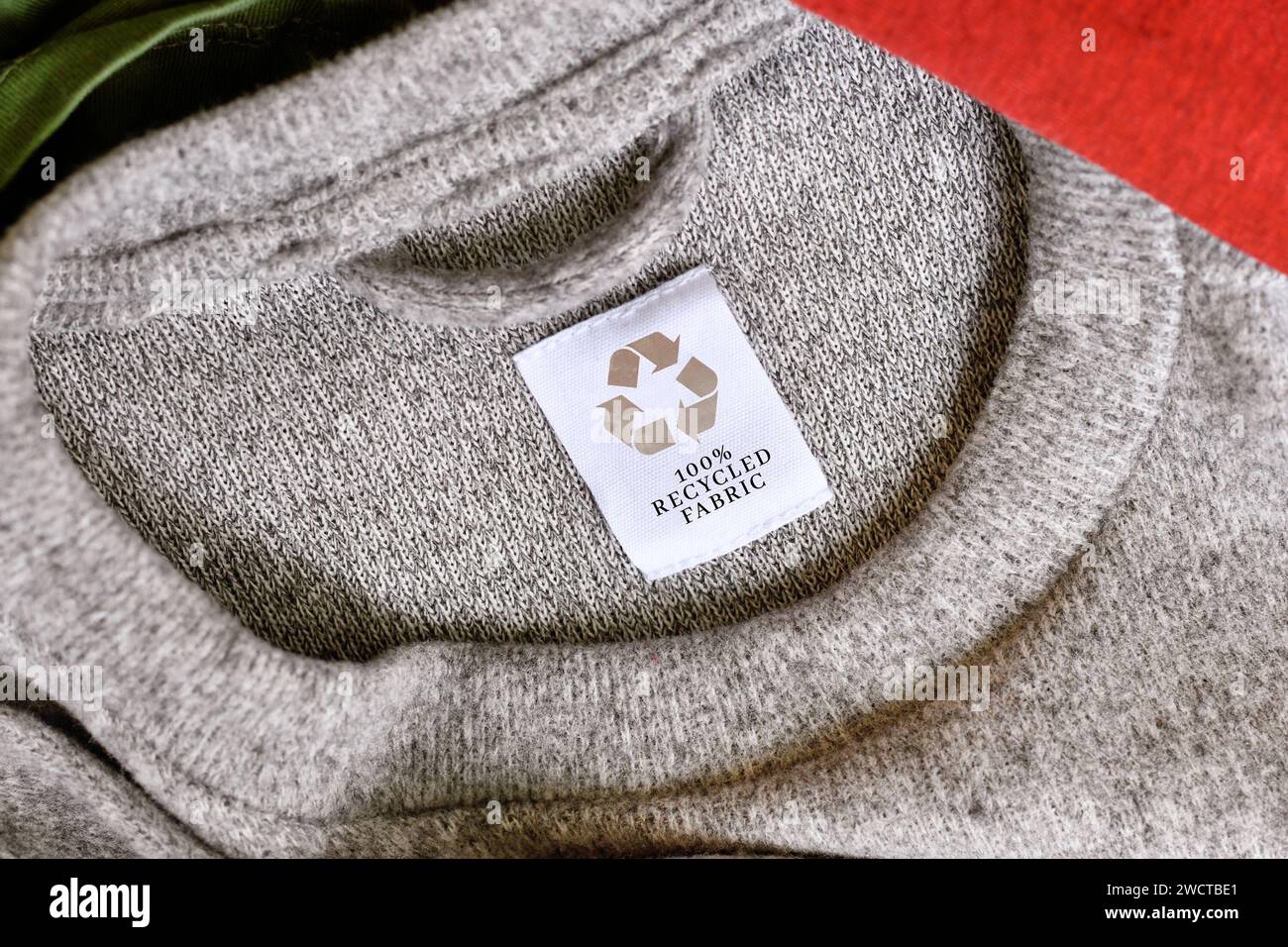Grauer Pullover mit Aufschrift „100 % recyceltes Material“ Stockfoto