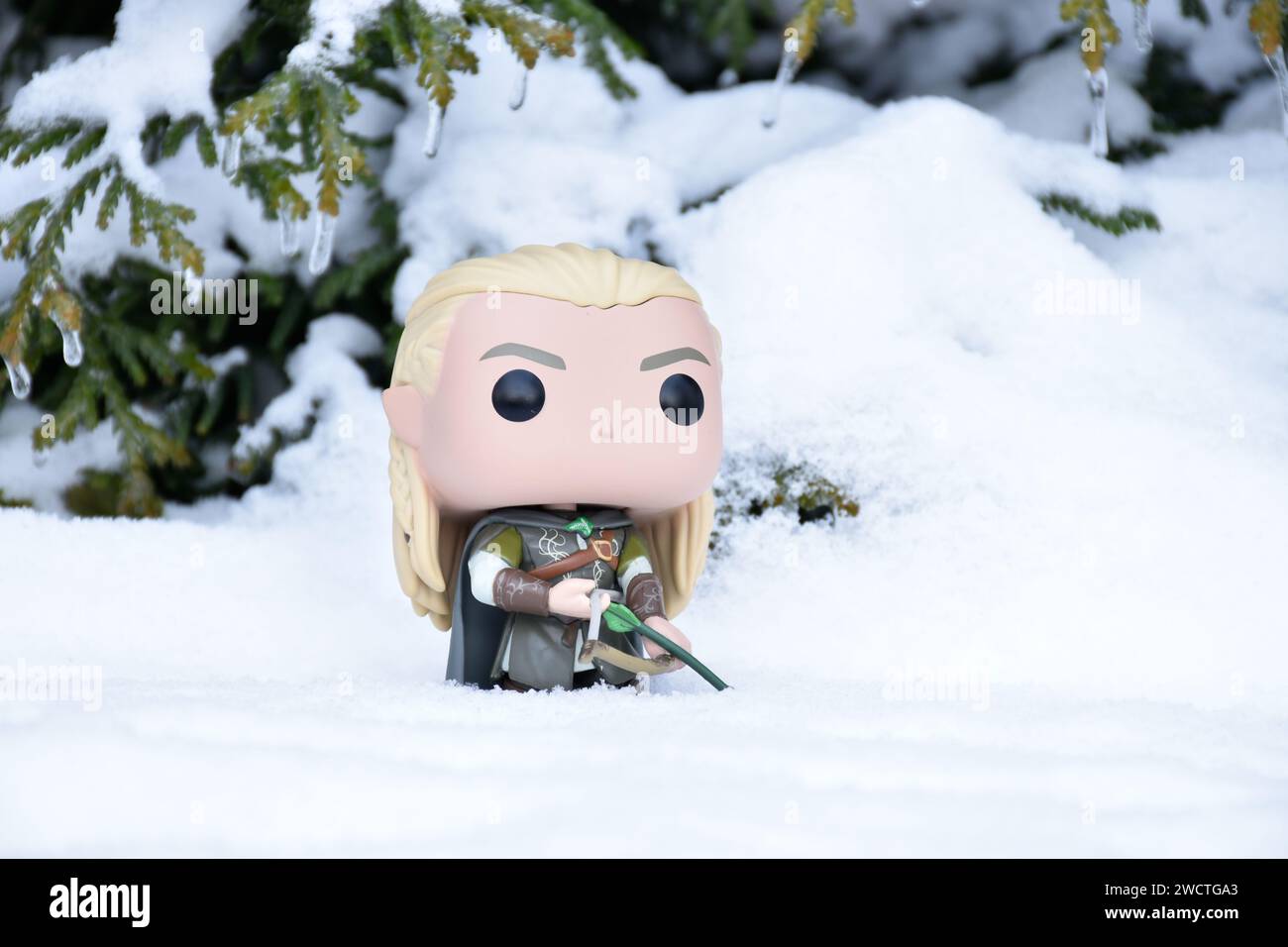 Funko Pop Actionfigur von Elf Legolas aus dem Fantasy-Film der Herr der Ringe. Krieger, der Bogen und Pfeil hält. Winterwald, Schnee, grüne Wälder. Stockfoto