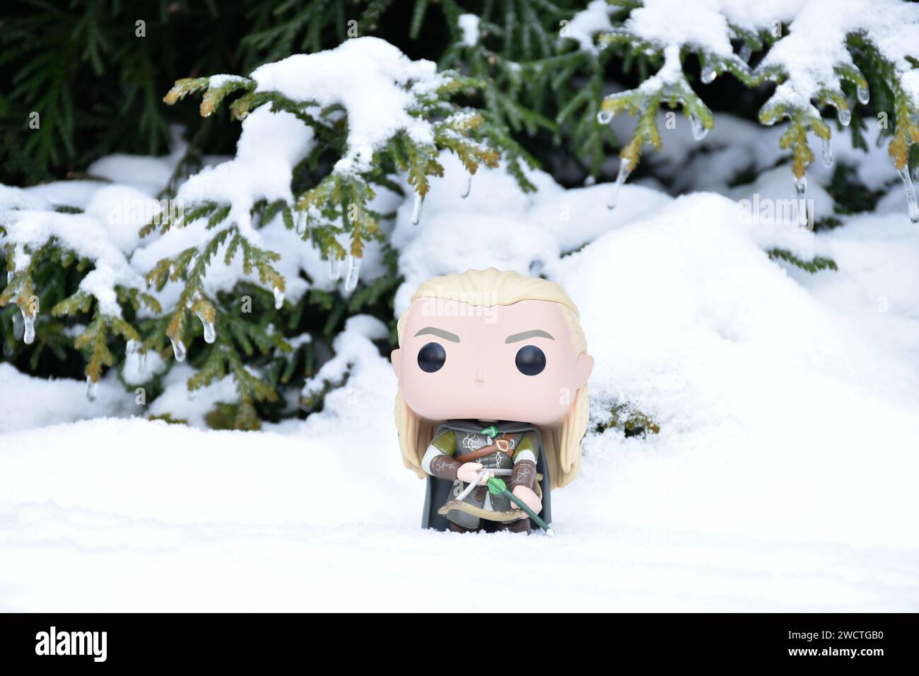 Funko Pop Actionfigur von Elf Legolas aus dem Fantasy-Film der Herr der Ringe. Krieger, der Bogen und Pfeil hält. Winterwald, Schnee, grüne Wälder. Stockfoto