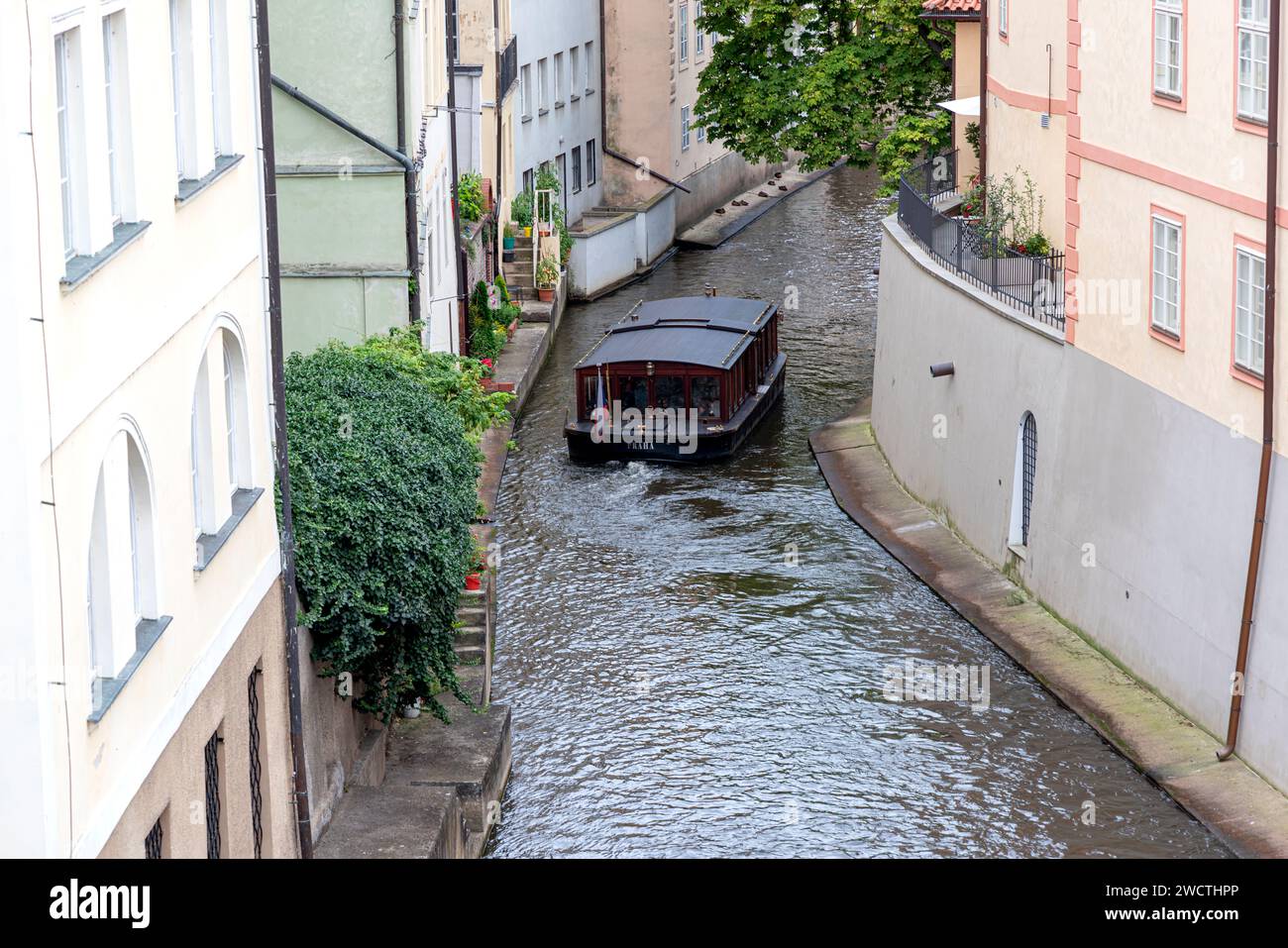 Foto in Prag, Tschechische Republik, mit einem Blick auf die Moldau von einer Brücke aus, mit einem antiken Boot im Vordergrund Stockfoto