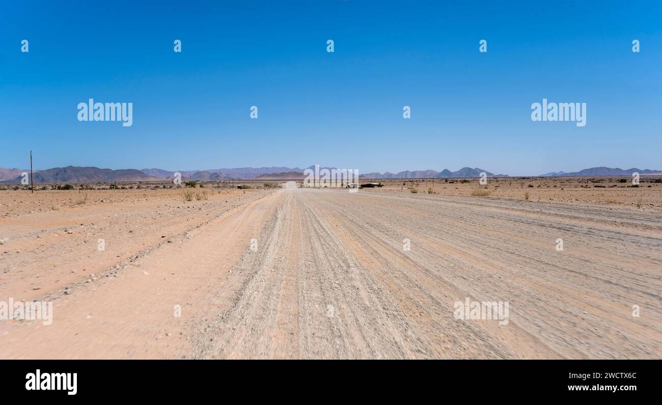 Landschaft mit C19 Schotterstraße in der Wüste Naukluft, aufgenommen im hellen Licht des späten Frühlings in der Nähe von Sesriem, Namibia, Afrika Stockfoto