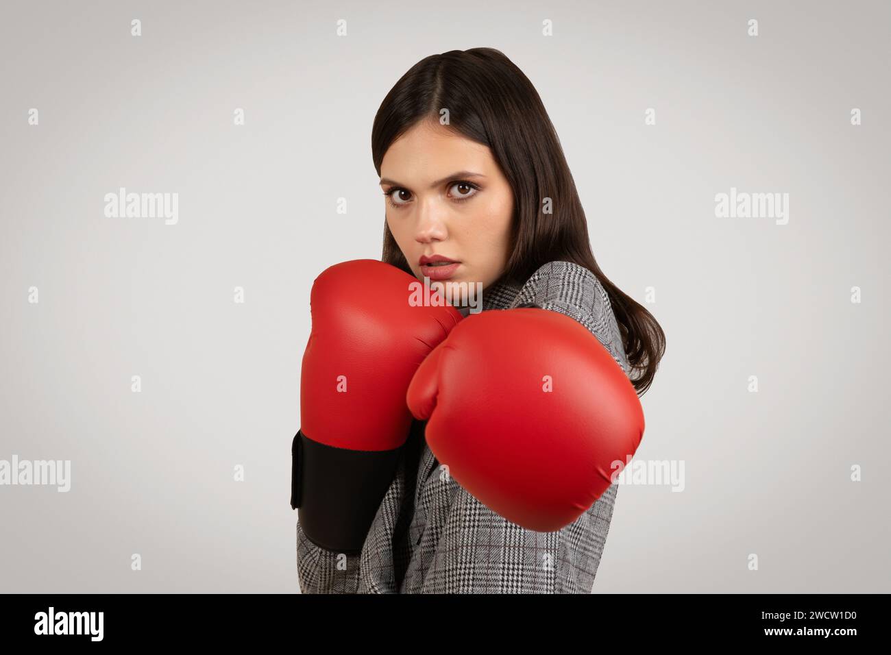 Entschlossene Frau mit Boxhandschuhen, heftig und defensiv Stockfoto