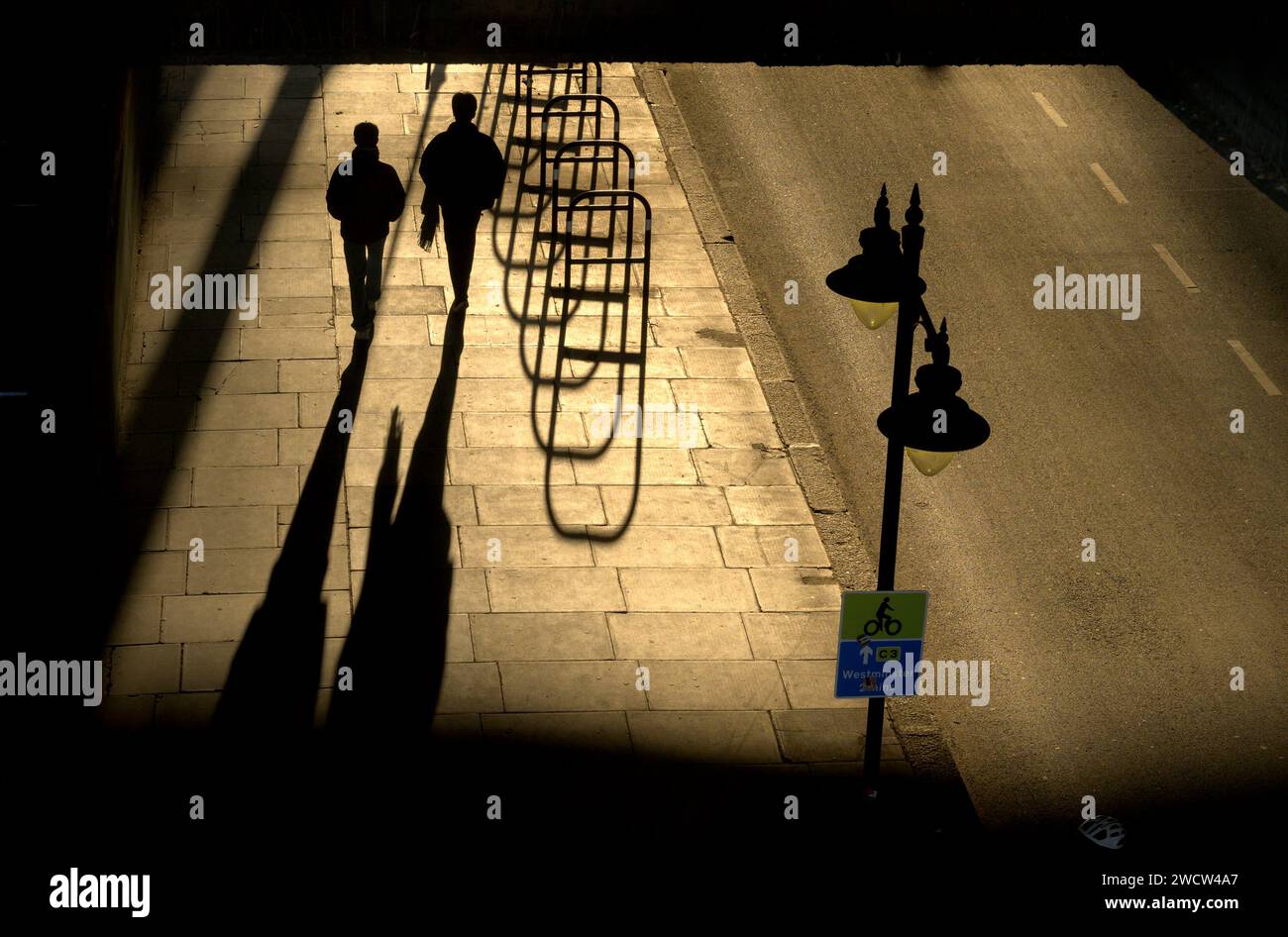 London, Großbritannien. Schatten unter der Waterloo Bridge am Abend - Menschen und Fahrradständer Stockfoto