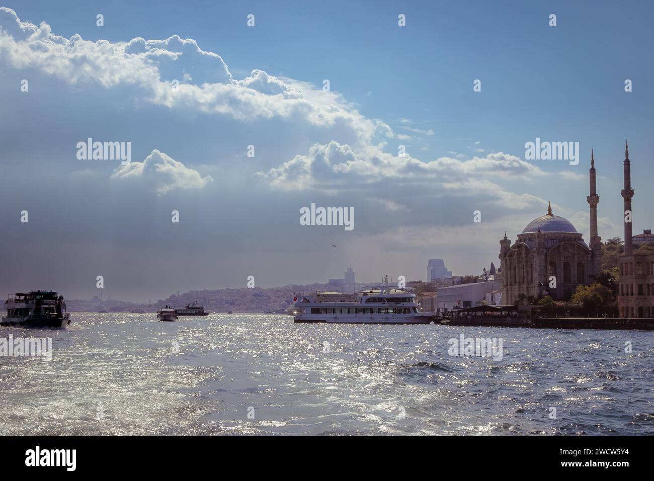 Grand Mecidiye Moschee auf dem Bosporus, gefangen von einem Boot bei Sonnenaufgang vor einer dramatischen Himmelskulisse in Istanbul, Türkei Stockfoto