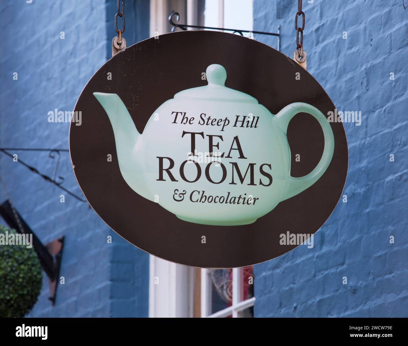Lincoln, Lincolnshire, England. Schild mit einer traditionellen Teekanne, die über dem Eingang zu den Steep Hill Tea Rooms & Chocolatier hängt. Stockfoto