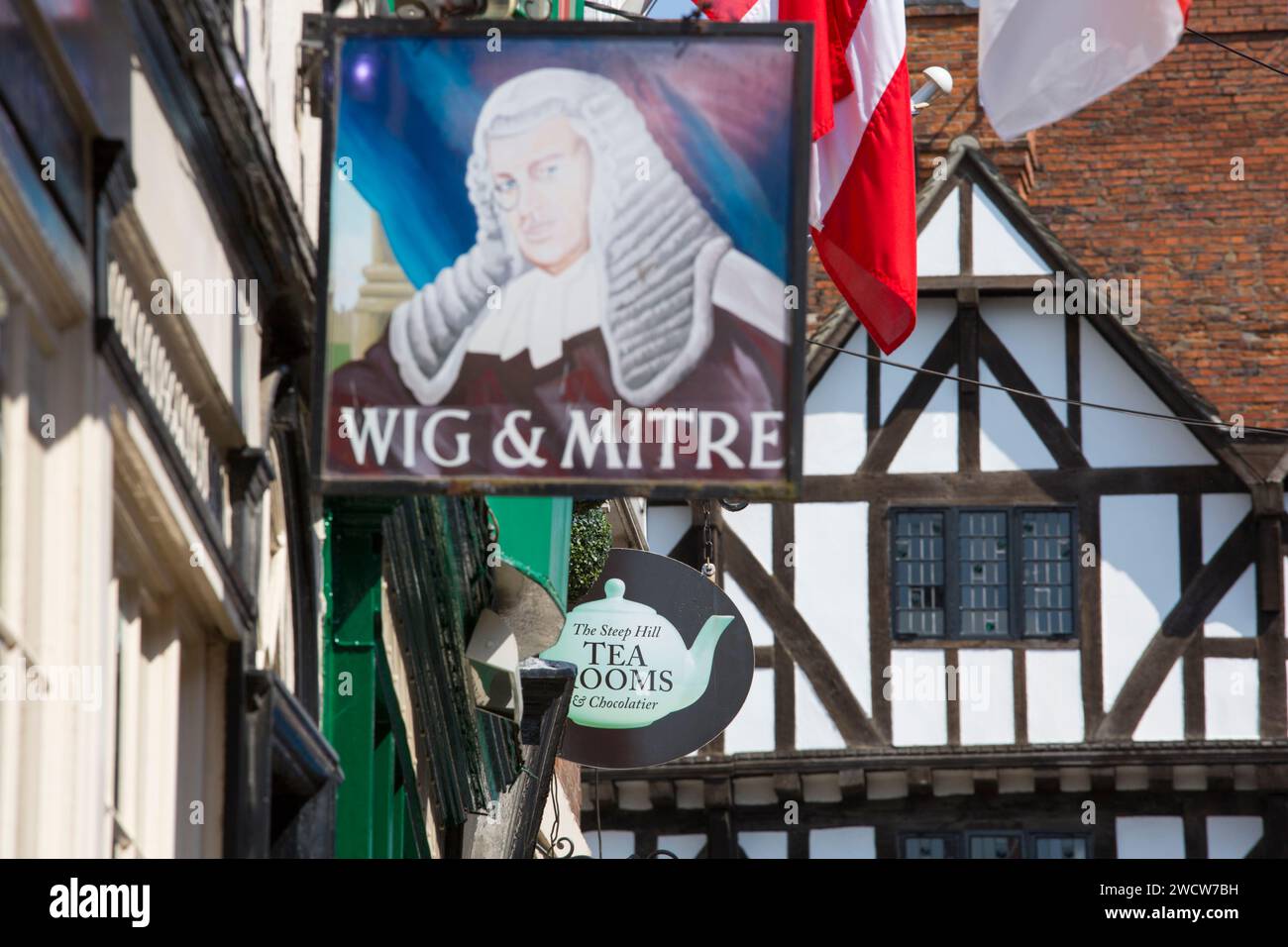 Lincoln, Lincolnshire, England. Schilder hängen über einer traditionellen Teestube und einem öffentlichen Haus am steilen Hügel, im Leigh-Pemberton House aus dem 16. Jahrhundert. Stockfoto