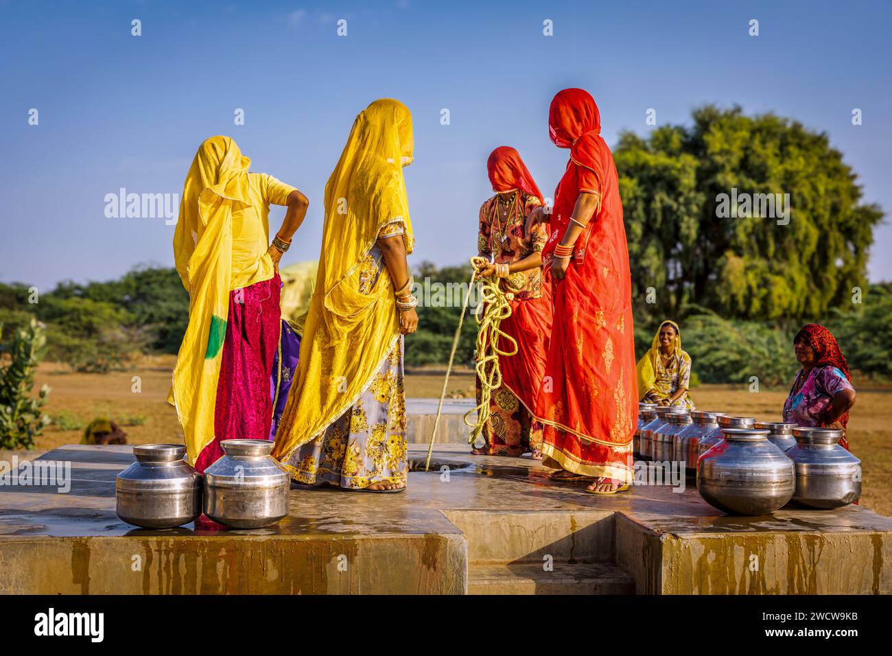 Frauen, die Wasser aus einem Brunnen der Gemeinde sammeln, Thar-Wüste, Rajasthan, Indien Stockfoto