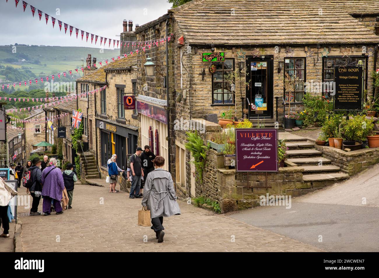 Großbritannien, England, Yorkshire, Worth Valley, Haworth, Main Street, Besucher auf einem Kopfsteinpflasterberg Stockfoto