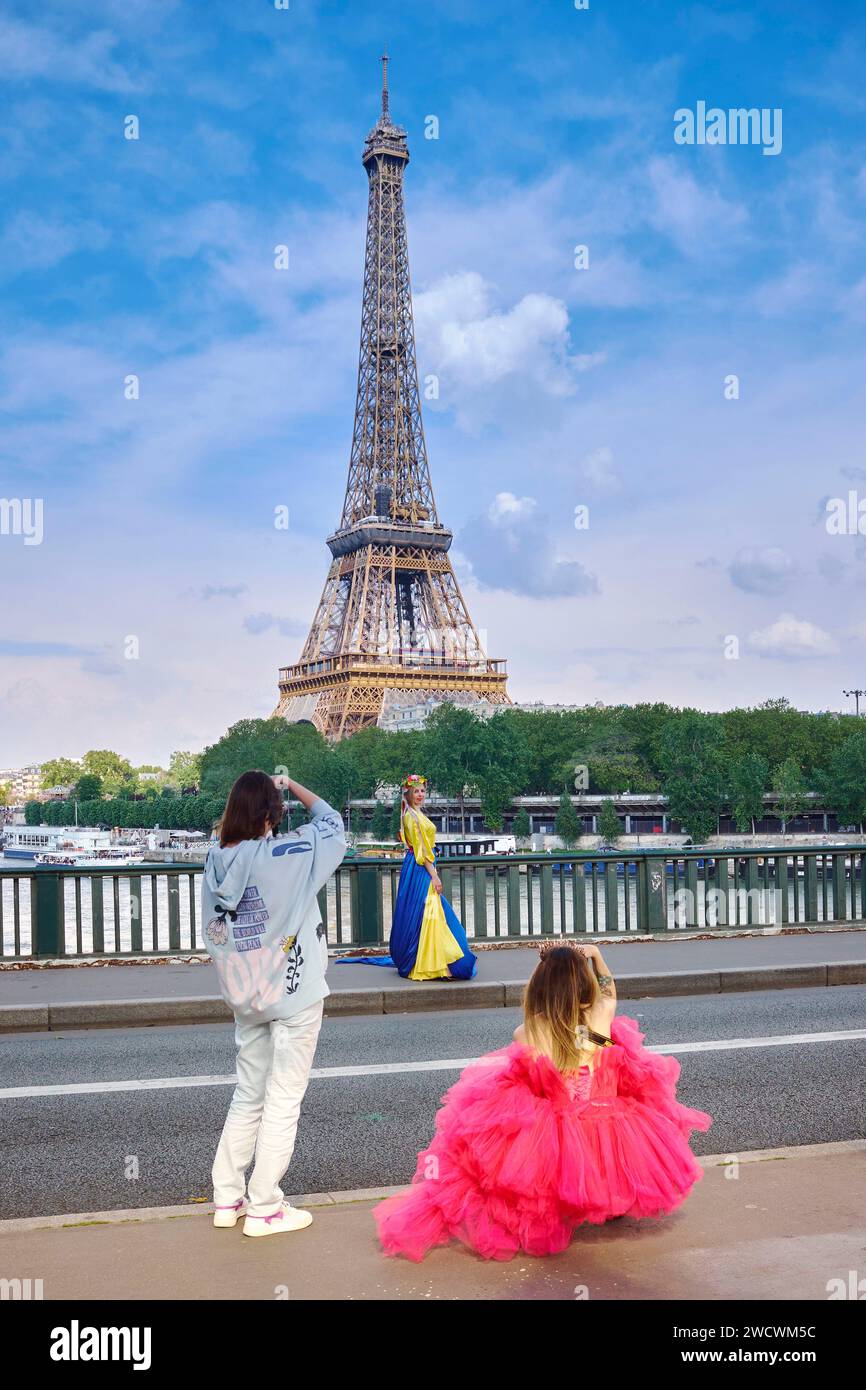 Frankreich, Paris, Bir-Hakeim-Brücke, Frau in einem Kleid in den Farben der Flagge der Ukraine und mit einem Blumenkranz, die ein Foto vor dem Eiffenturm macht Stockfoto