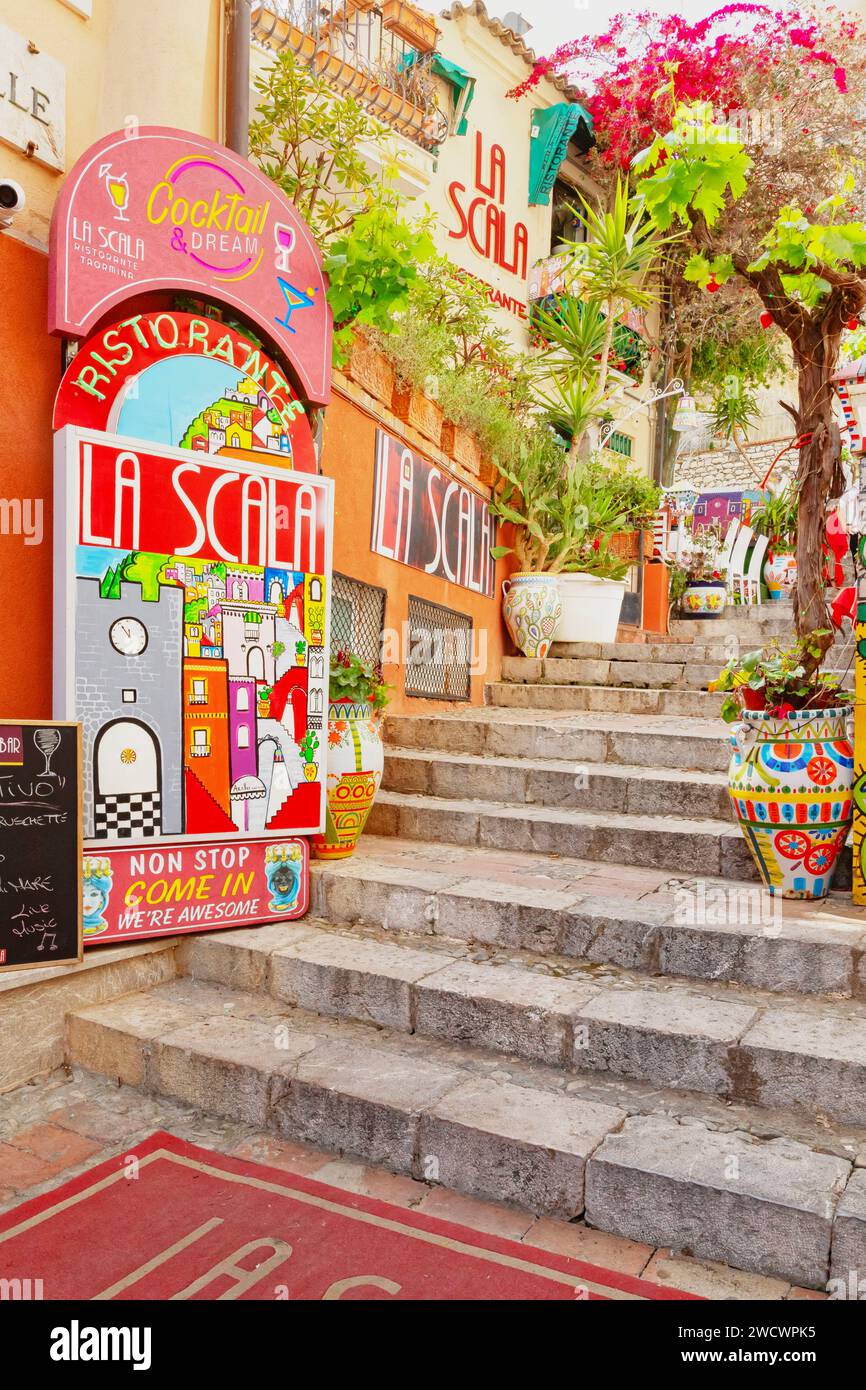 Italien, Sizilien, Taormina, Straße in der Altstadt mit Werbetafeln und Kunstwerken Stockfoto